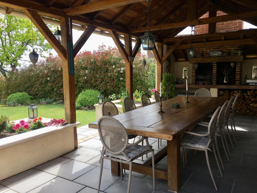 a wooden table and chairs on a patio at Libellule in Coussac-Bonneval