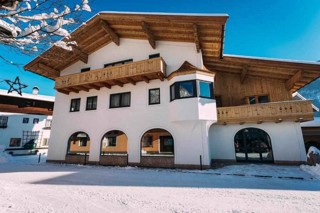 a large white building with a wooden roof at Voglstätter Appartements Lofer in Lofer