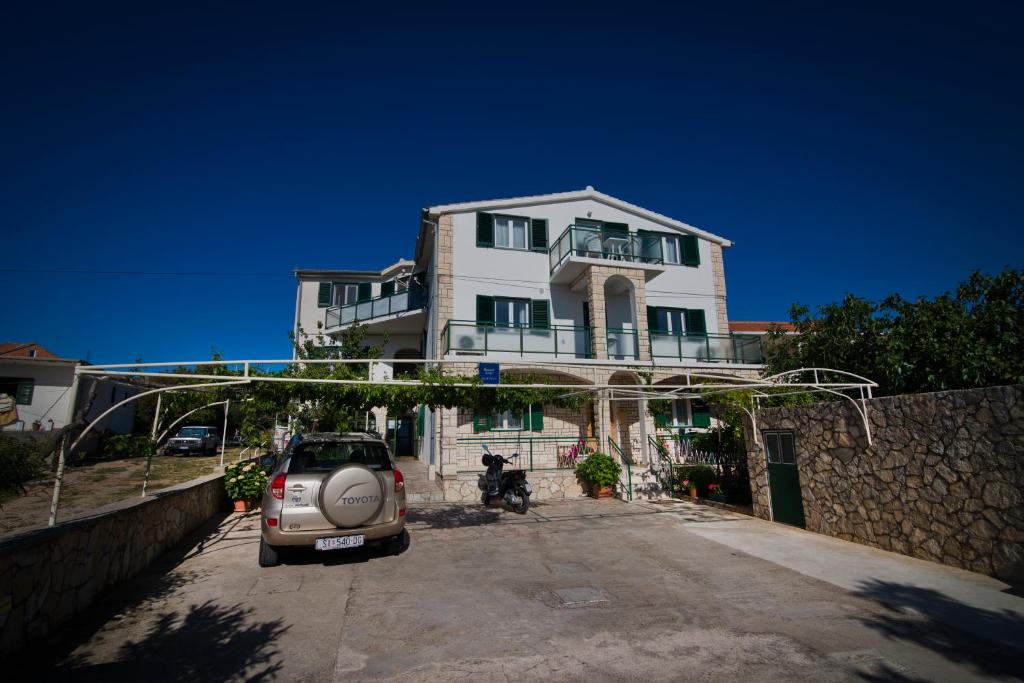 a small car parked in front of a house at Apartmani i sobe Josica in Jezera