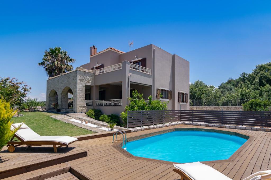 a villa with a swimming pool in front of a house at Iris Villa in Prinés