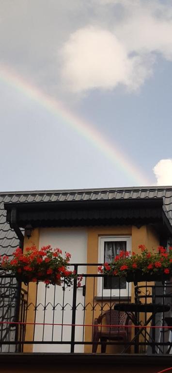 a house with red flowers on a balcony at Wczasy u Jasia in Trzęsacz
