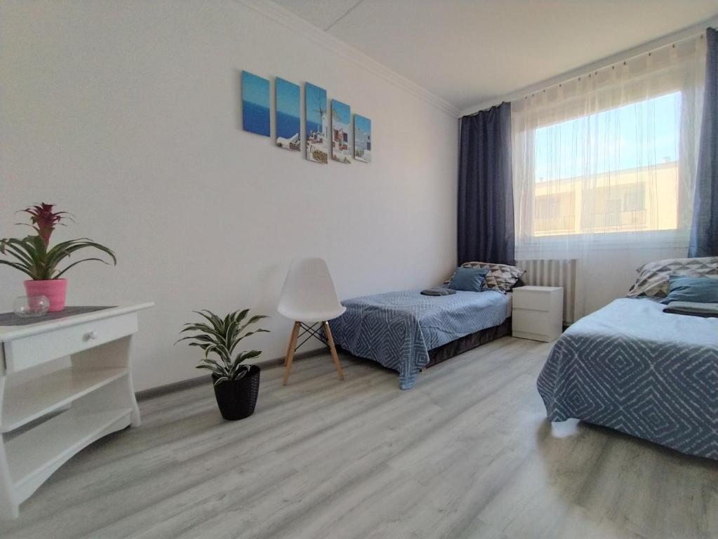 - une chambre avec 2 lits, un bureau et une fenêtre dans l'établissement Hanna Apartman, à Veszprém