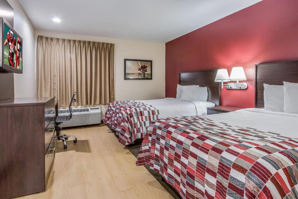 a hotel room with two beds and a television at Red Roof Inn Grand Junction in Grand Junction