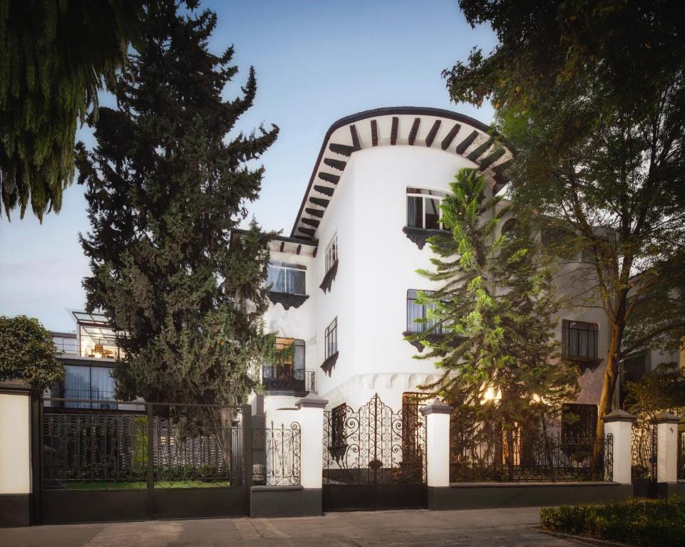 a white house with an arch over a gate at Pug Seal Polanco Allan Poe in Mexico City