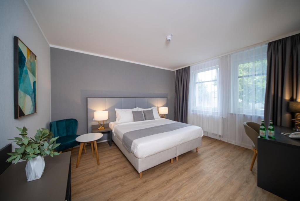 a hotel room with a bed and a table and chairs at Emily Hotel Leipzig Neue Messe in Leipzig