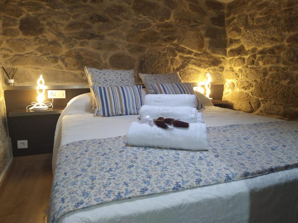 - une chambre avec un lit et des serviettes dans l'établissement O Recuncho do Maio, à Muros