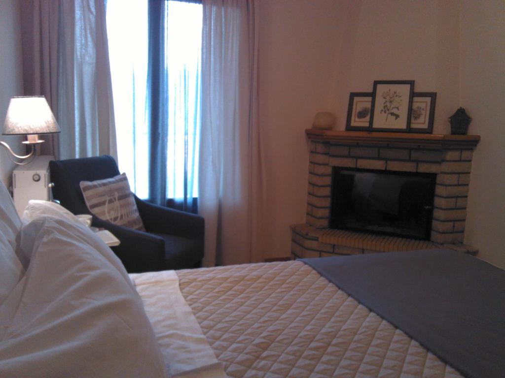 カルペニシにあるMenta( Archontiko Machalioti )のベッドルーム(暖炉、ベッド1台、椅子付)