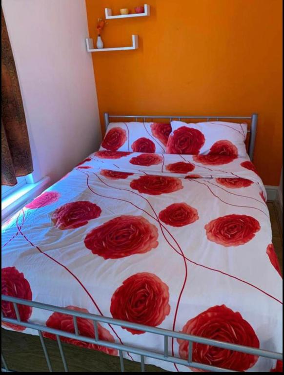 a bed with a bunch of red roses on it at 03 Bedroom Apartment-Self Check in in London