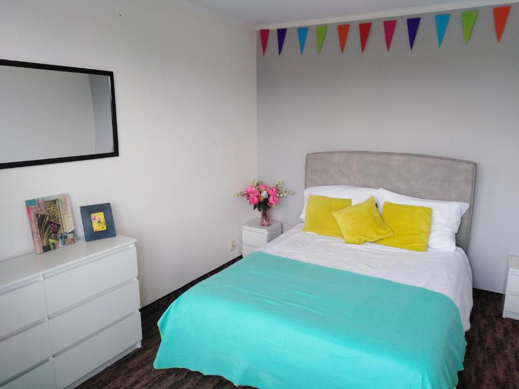 a bedroom with a large bed with yellow pillows at 7 Niebo in Augustów