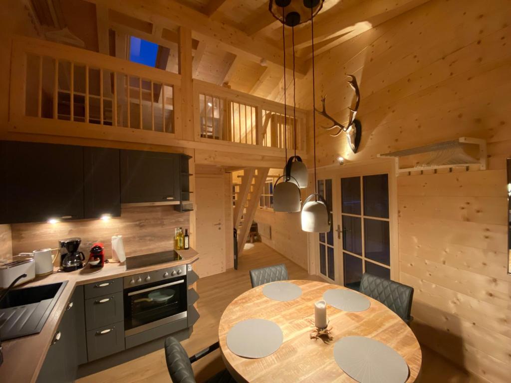 eine Küche und ein Esszimmer mit einem Tisch in einer Hütte in der Unterkunft Karwendel Chalet in Scharnitz
