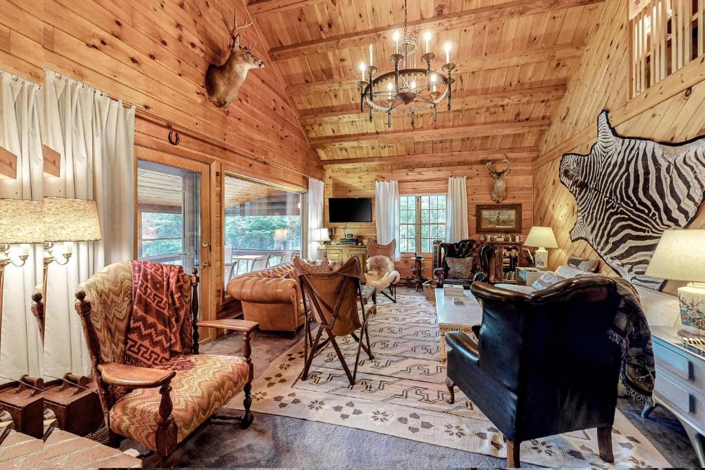 una sala de estar con paredes de madera y una lámpara de araña. en The River Lodge en Rockwood