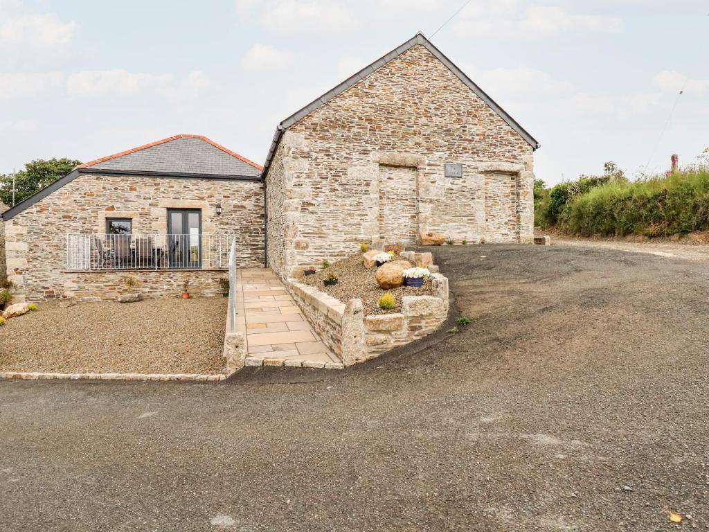 a stone building with a driveway in front of it at The Granary in Bodmin
