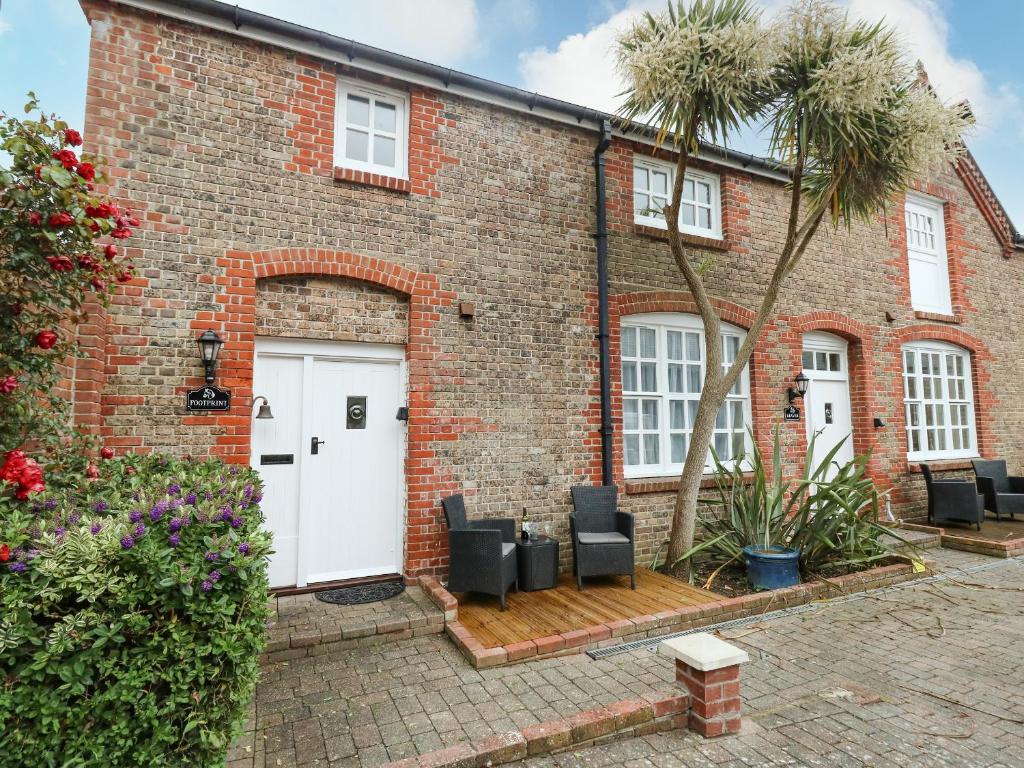 ein Backsteinhaus mit weißen Türen und einer Palme in der Unterkunft Footprint in Weymouth