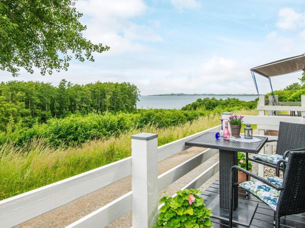 eine Terrasse mit Tisch und Stühlen und Blick auf das Wasser in der Unterkunft 4 person holiday home in Aabenraa-By Traum in Aabenraa
