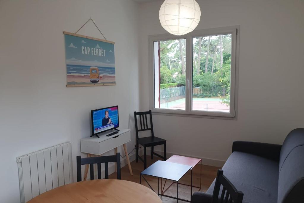 a living room with a couch and a desk with a computer at Modern Apartment Near The Sea in La Teste-de-Buch