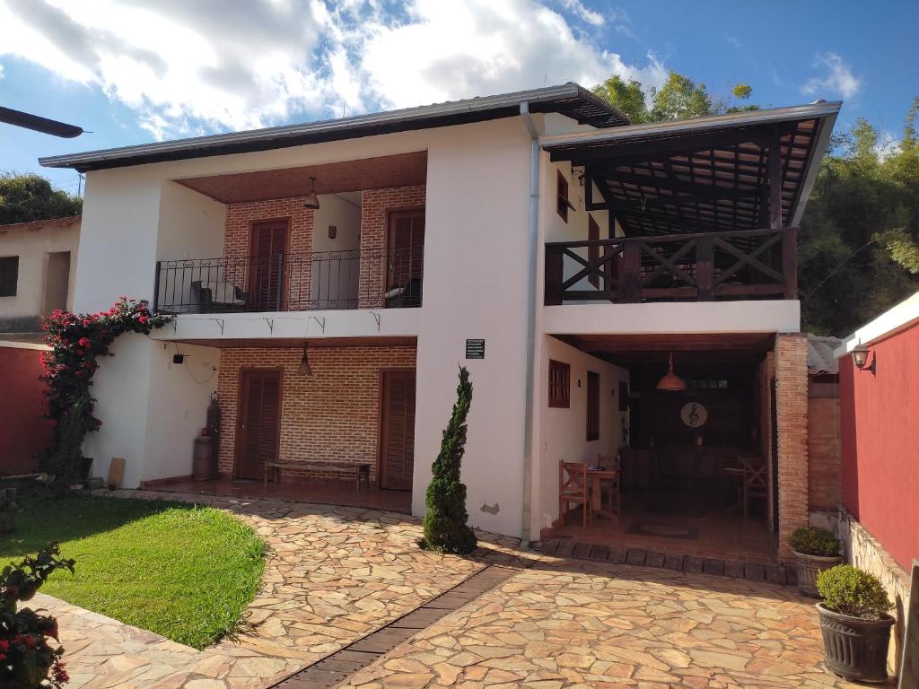 Casa blanca con balcón y patio en Pousada Portas da Lua en Catas Altas