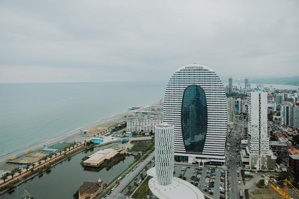 a tall building in a city next to a body of water at Batumi Orbi City sea view in Batumi