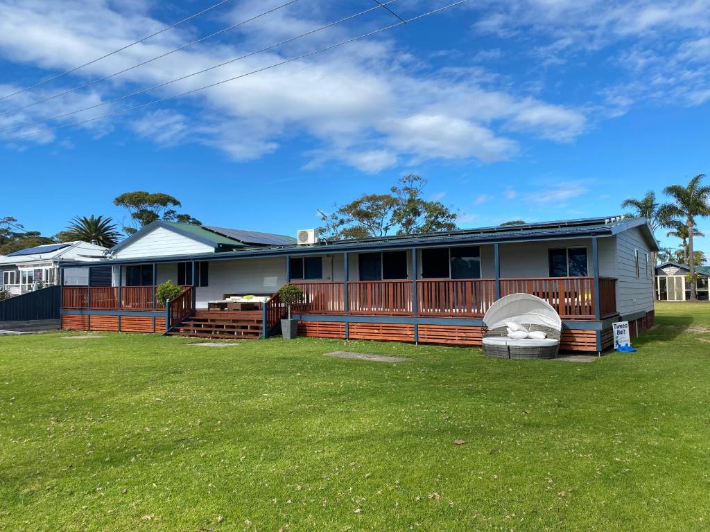 a house with a large yard in front of it at Amaroo Resort in Sussex Inlet