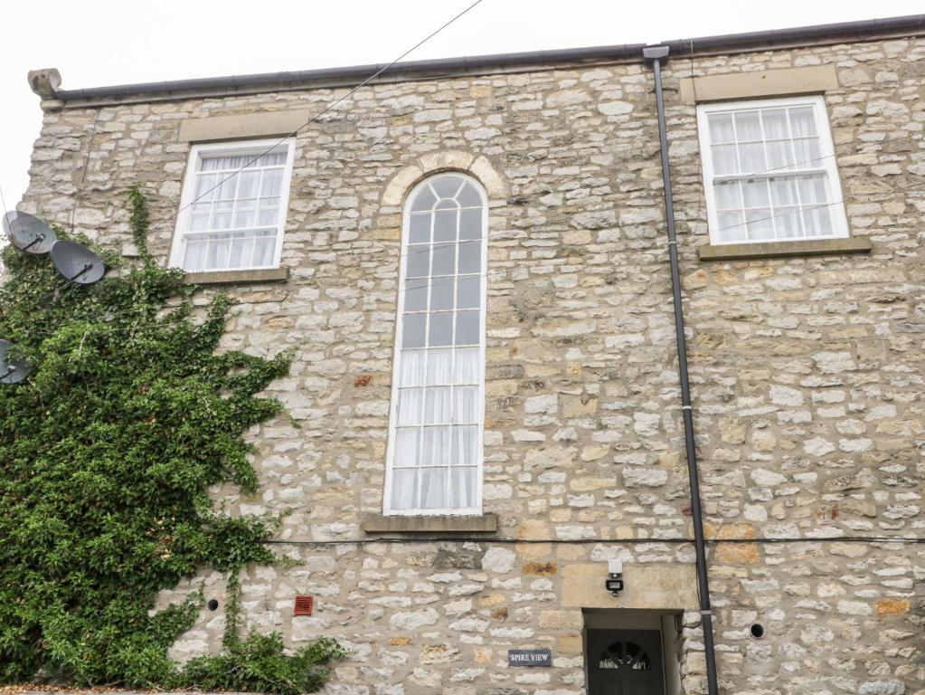 - un vieux bâtiment en pierre avec une grande fenêtre dans l'établissement Spire View, à Pickering