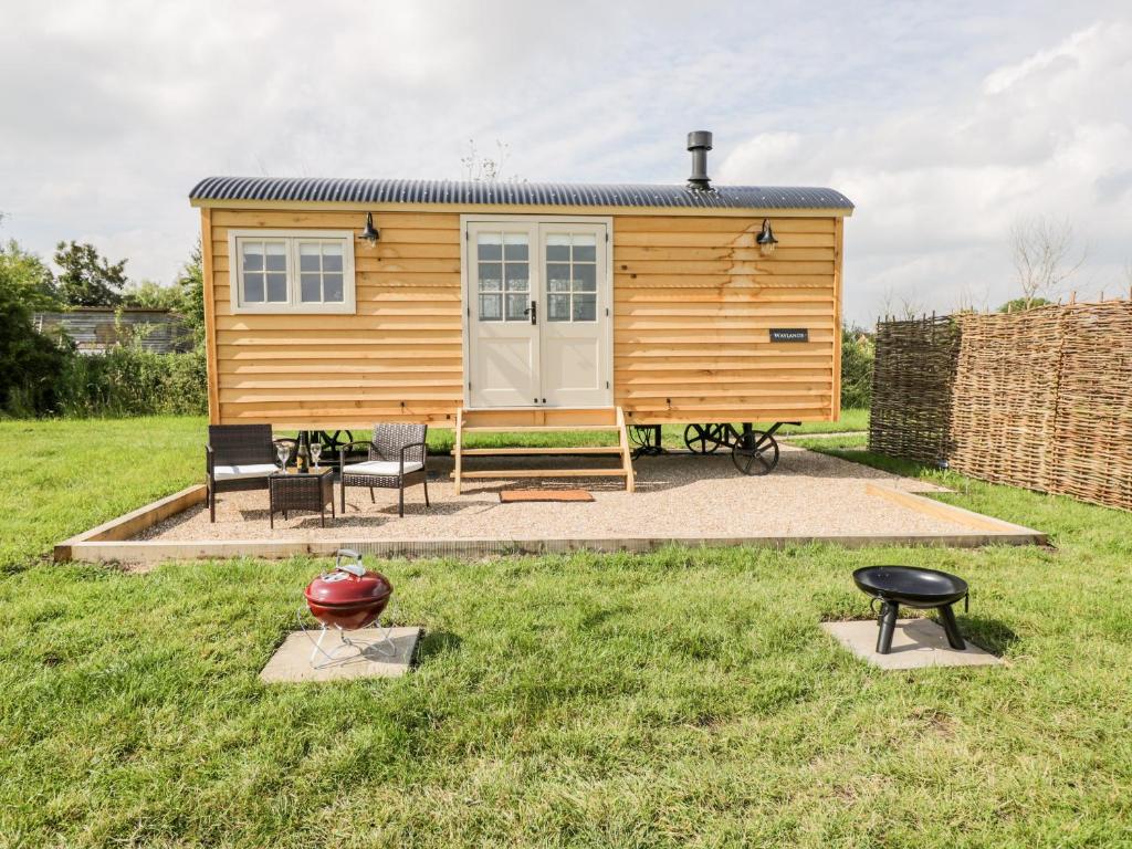 a tiny house in a yard with two chairs and a table at Waylands in Faringdon