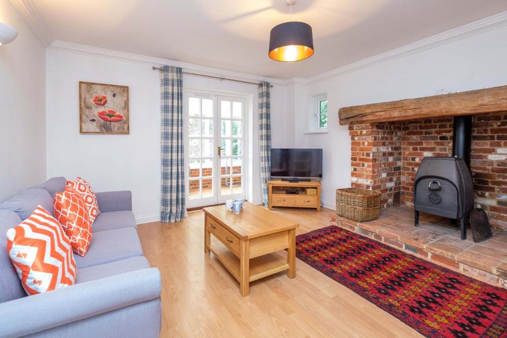 a living room with a blue couch and a fireplace at Bryony Cottage in Aldeburgh