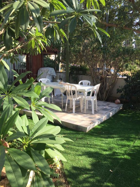 a patio with a table and chairs in a yard at בית מרום in Gan Shomeron