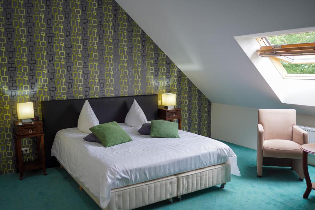 a bedroom with a bed and a chair at Hotel Prins van Oranje in Diest
