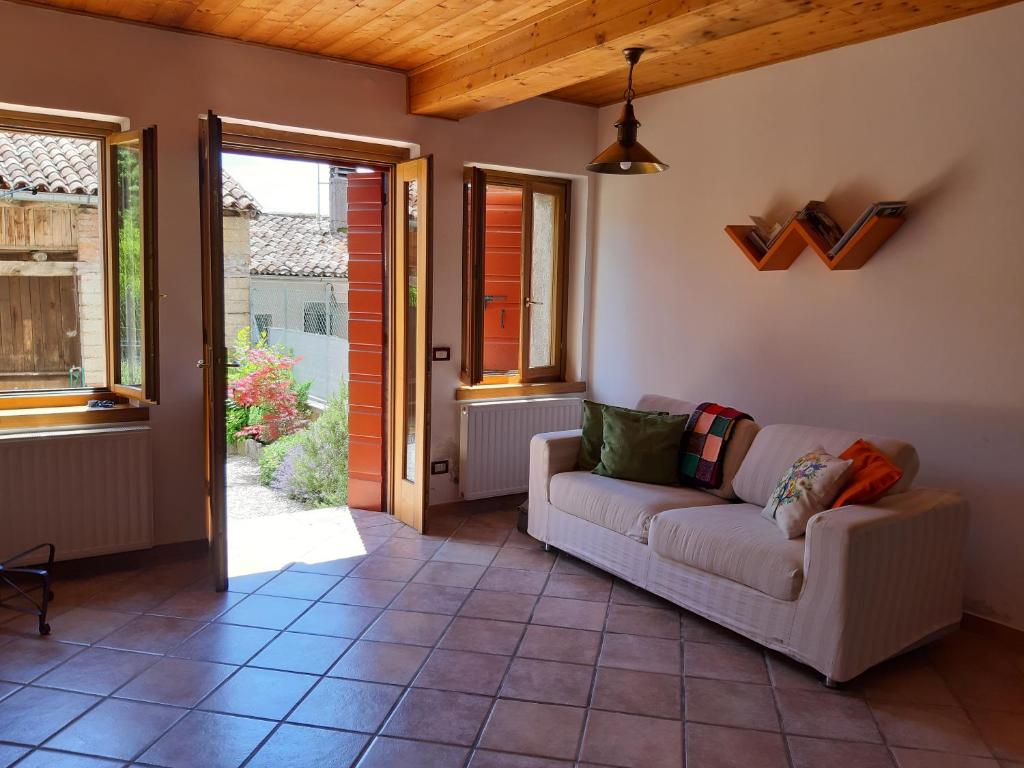 a living room with a couch on a tile floor at Casa Nonna Silla Cison di Valmarino in Cison di Valmarino