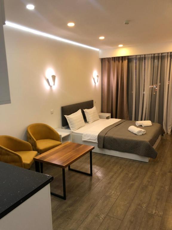 a hotel room with a bed and a table and chairs at panorama beach tower in Batumi