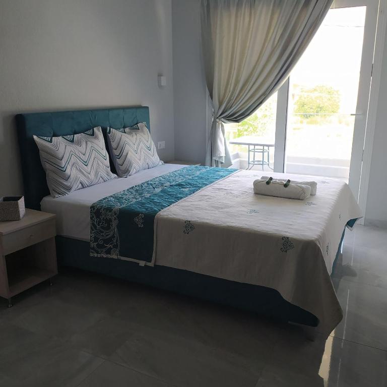 sypialnia z dużym łóżkiem i oknem w obiekcie Mei's luxury apartments w Stavrós