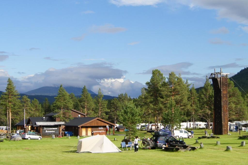 a group of people in a field with a tent at Jotunheimen Feriesenter in Heidal