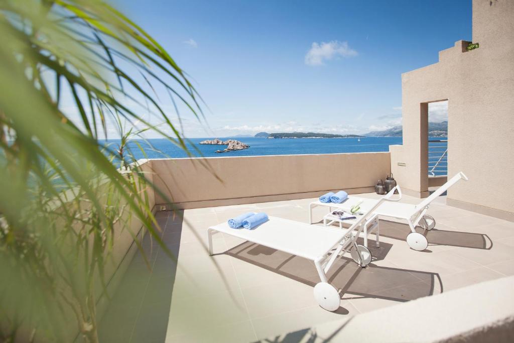 a balcony with a white chair and a view of the ocean at Hotel Dubrovnik Palace in Dubrovnik