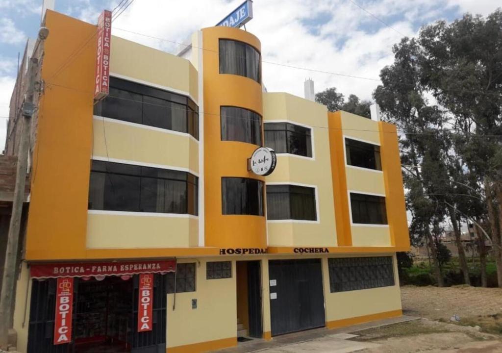 un edificio amarillo con un reloj en él en La Azotea, en Huancayo