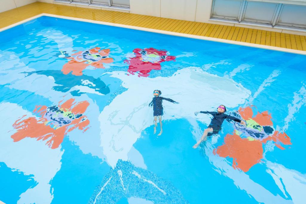 a pool with two people on top of a map of the world at Hotel Ocean (Kokusai-Dori) in Naha