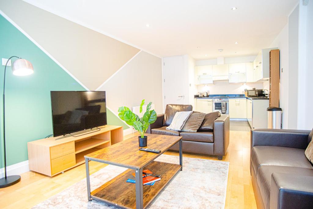 a living room with a couch and a television at One Bed Serviced Apt in Farringdon in London