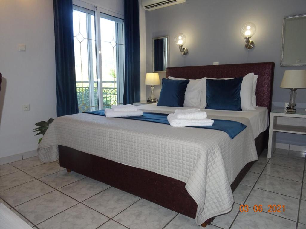 a bedroom with a large bed with blue and white sheets at Studios Anais - Thasos in Limenas