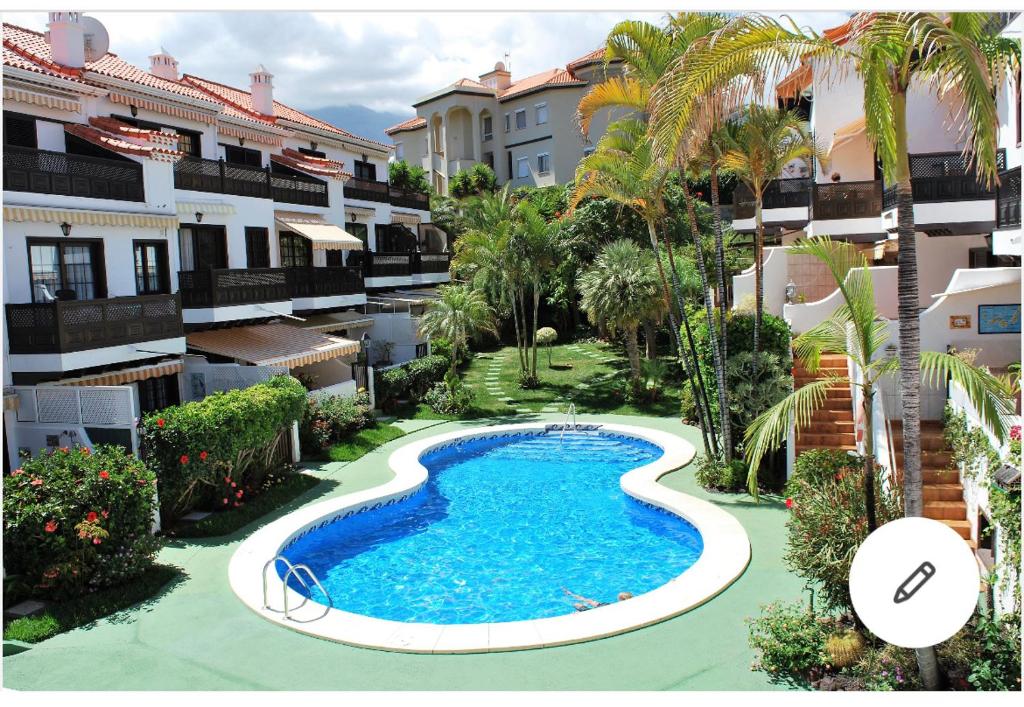 an overhead view of a swimming pool in the middle of buildings at Apartamento con jardín y piscina B in Puerto de la Cruz