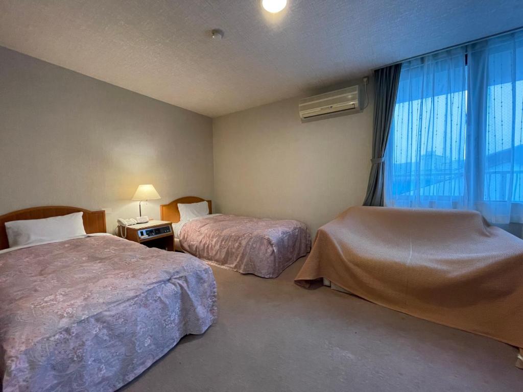 Postel nebo postele na pokoji v ubytování Hotel Ginsui