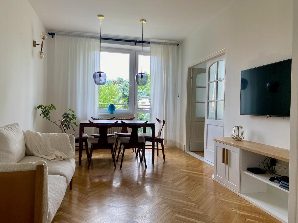 a living room with a table and a couch at Chic Apartment in vibrant area - National Stadium - Saska Kępa in Warsaw