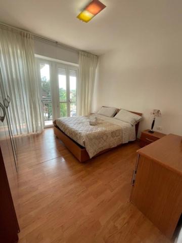 a bedroom with a bed and a large window at Affitti brevi Caterina in Seriate