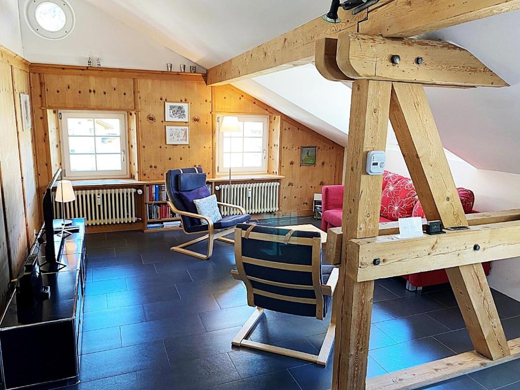 Cette chambre dispose d'une mezzanine avec un lit et des chaises. dans l'établissement Dachwohnung im Alpenstil, 60m2 für 2P, mit Garage - BM186, à Pontresina