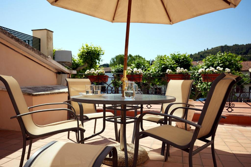 a table and chairs with an umbrella on a patio at Casa Maitetxu 2 in Puente la Reina