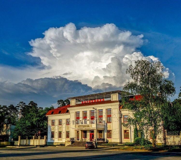 un gran edificio blanco con techo rojo en Бутик отель Боровница, en Solotcha