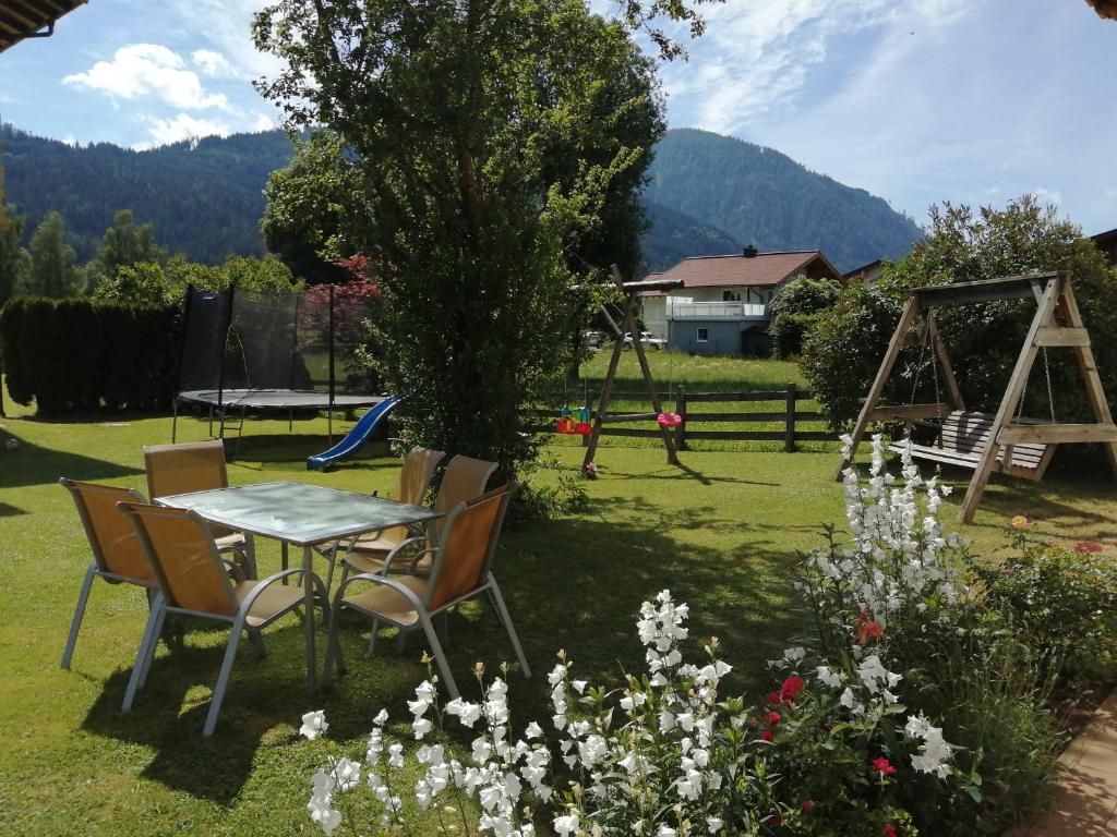a table and chairs in a yard with a playground at Landhaus Fingerhof in Flachau