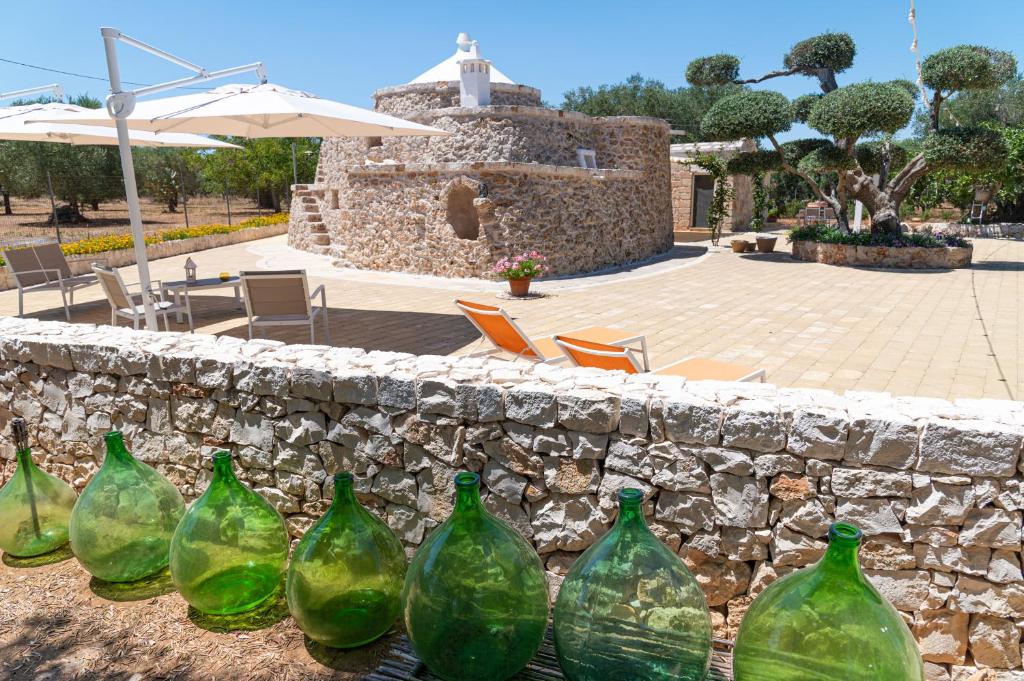 a group of green glass bottles sitting on a stone wall at Pietra800 in Mesagne