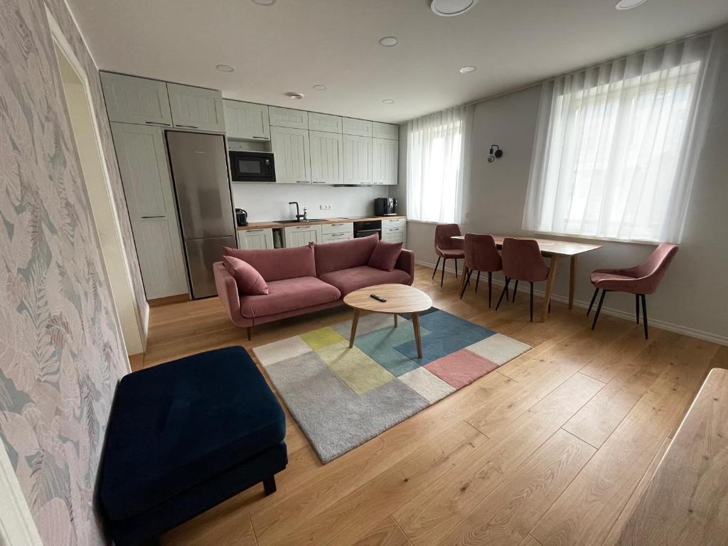 a living room with a couch and a table and a kitchen at Niidupuu Apartment in Kuressaare