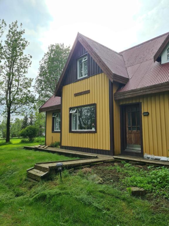 uma casa amarela com um telhado de gambrel em Heidi Guesthouse em Selfoss