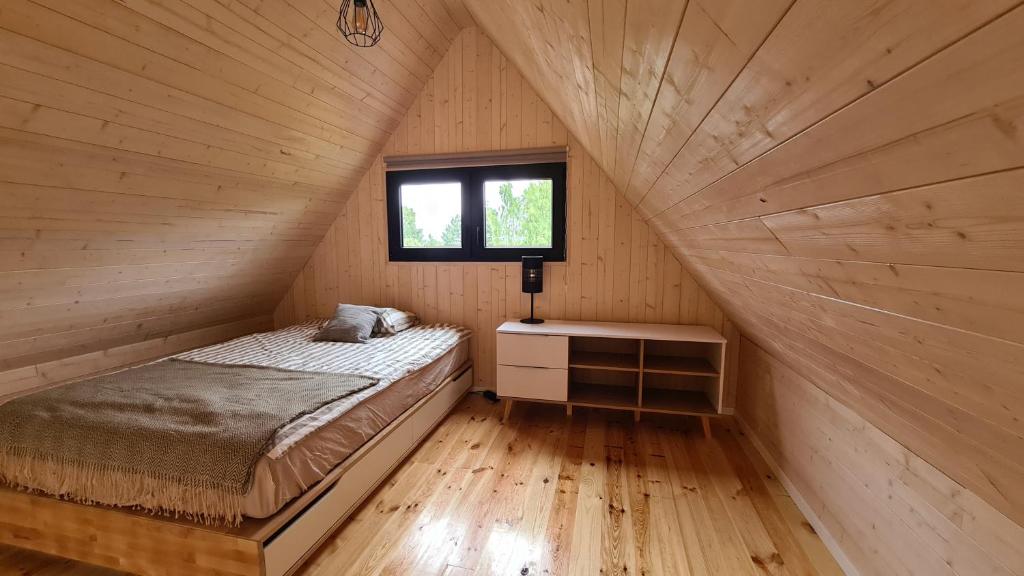 a bedroom with a bed in a wooden cabin at Sasinko Mini in Sasino