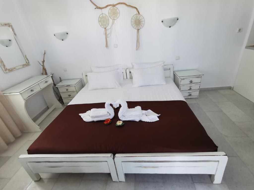 1 dormitorio con 1 cama con toallas en Vitzileos Studios, en Agios Prokopios