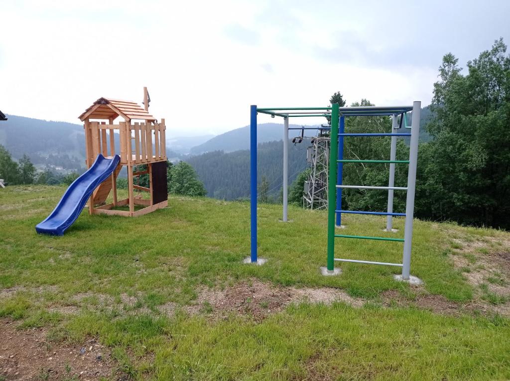 two childrens playground equipment in a field at apartmány Kynast in Albrechtice v Jizerských horách
